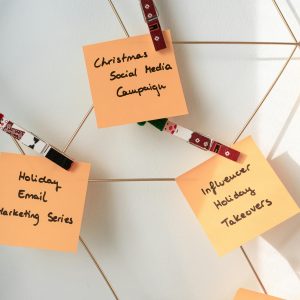 Sticky notes with holiday marketing ideas for Christmas social media and email campaigns.